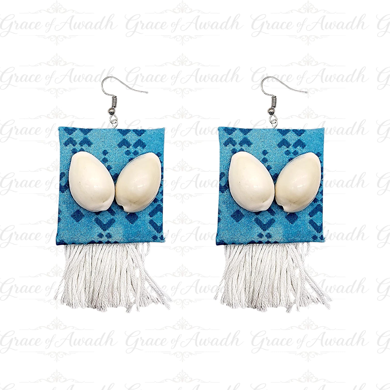 Pair of earrings with blue square design, white stones, and tassels on a white background. Gehna-e-Samundar blue patterned cowrie shell earrings with white tassels – Grace of Awadh