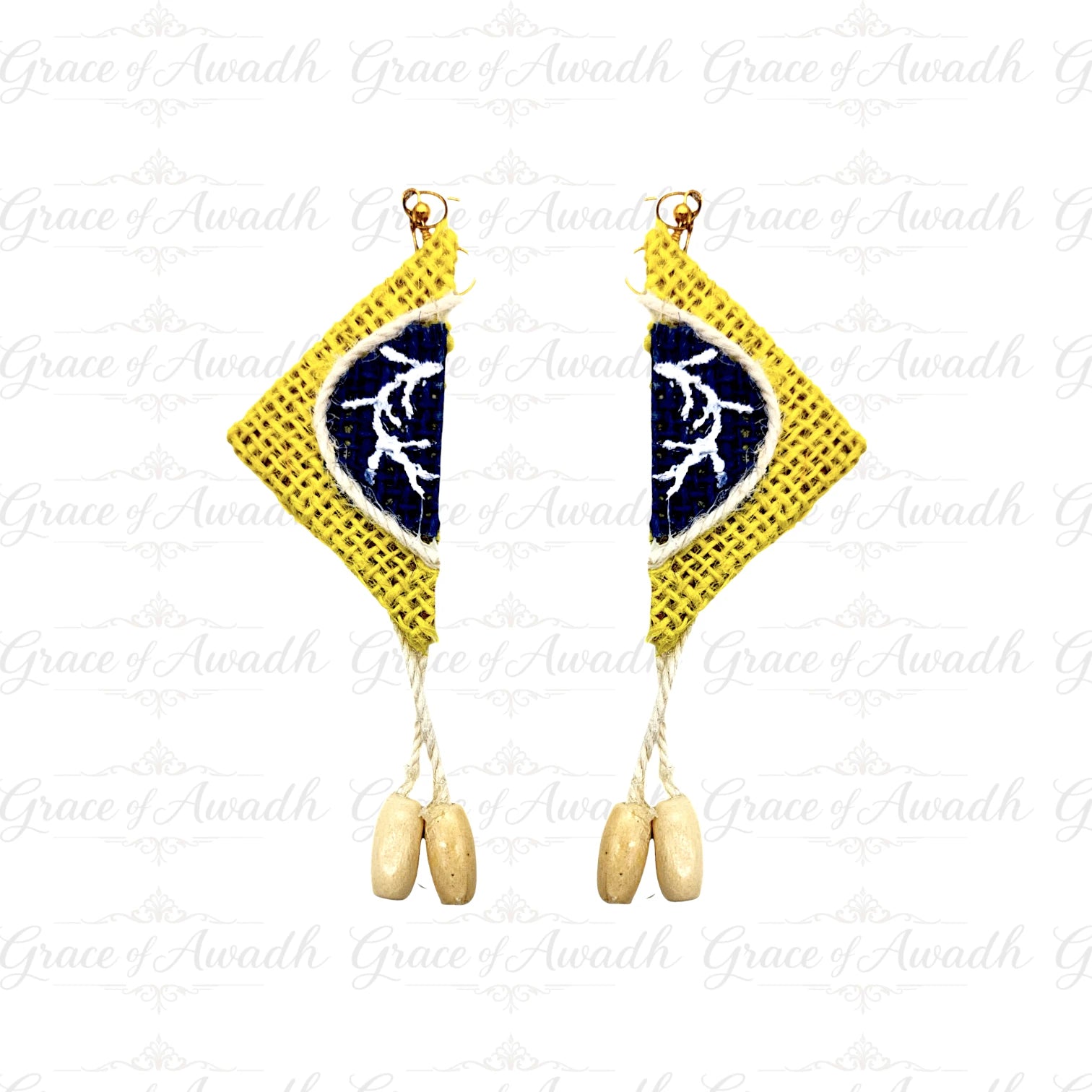 Pair of earrings with yellow diamond-shaped pendants and blue center on a white background. Noor-e-Baagh handcrafted yellow and blue fabric earrings with tassel drops – Grace of Awadh